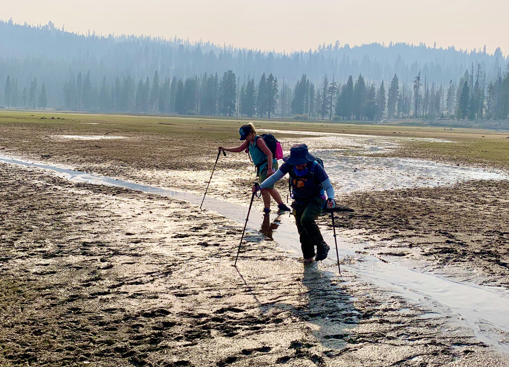 Crossing the mudflat where the water receded in Snag Lake can be a very muddy endeavor.