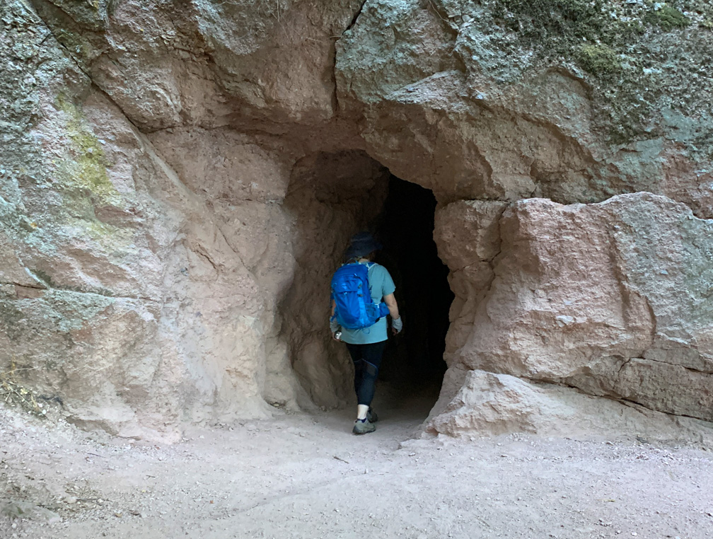 A hiker enters a cave on the Moses Springs Trail to Bear Gulch Reservoir at Pinnacles National Park.