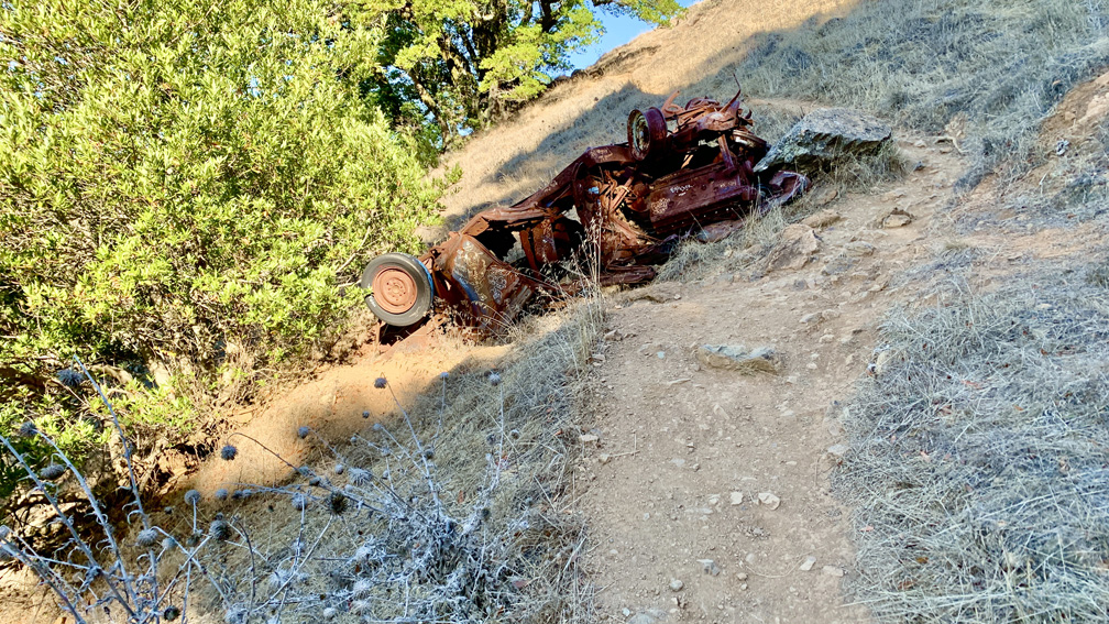 Along the Coast Trail on Mount Tamalpais is a rusted out overturned crashed car.